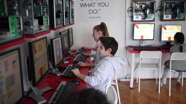 在现代计算机学校教室里使用台式电脑的孩子们视频下载