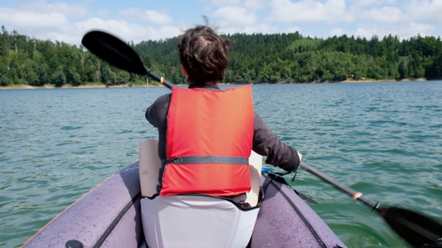 克罗地亚戈尔斯基科塔尔，一名妇女在洛克夫湖上划着充气皮艇视频素材