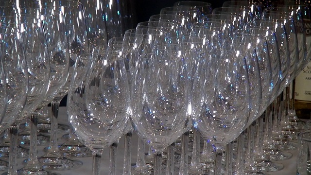 近距离的透明玻璃酒杯在宴会桌上闪闪发光。视频下载
