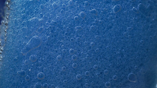 蓝色洗碗海绵，选择性聚焦。泡沫,在水中。宏观多孔海绵视频素材