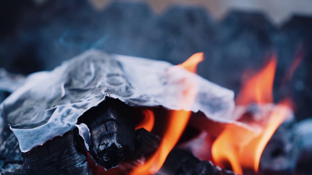 在篝火中燃烧纸张时产生火焰视频素材