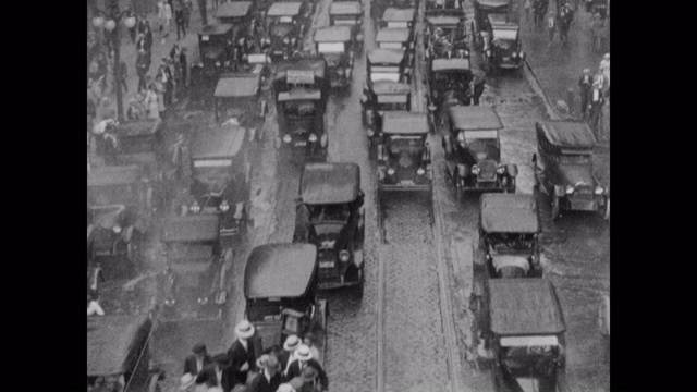 20世纪20年代-倾斜镜头在下雨时城市街道上繁忙的交通，芝加哥，伊利诺伊州，美国视频下载