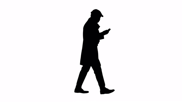 剪影成年男子戴着医用防护口罩一边打电话一边走路视频素材