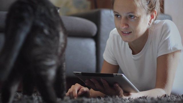 一名女子用平板电脑戏弄她的宠物视频素材