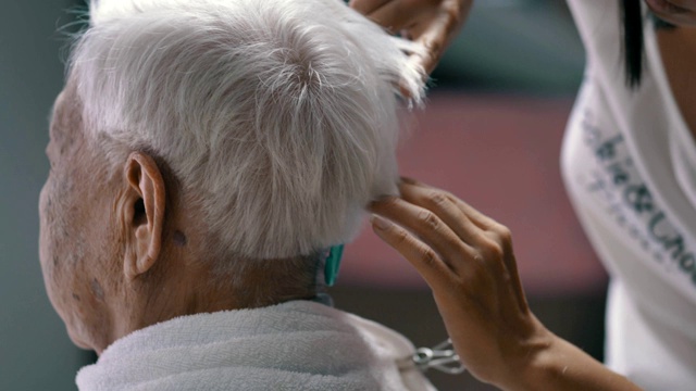 新冠肺炎隔离:女性在家剪祖母头发视频素材