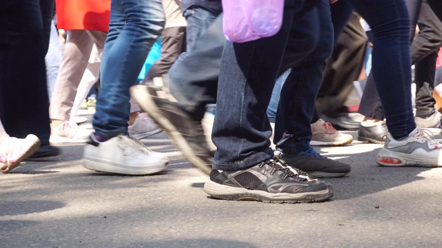 人群的腿人们走在街上。人群脚的特写视频素材