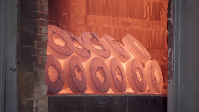 在铸造厂中装有红色金属工件的机器人可收放炉。用铸造制造金属制品的空间。充气模型铸造车间。高炉炼钢厂。视频素材