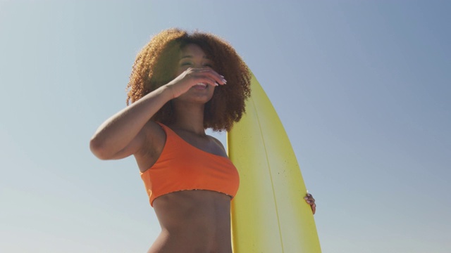 非洲裔美国妇女与冲浪板看海景视频素材