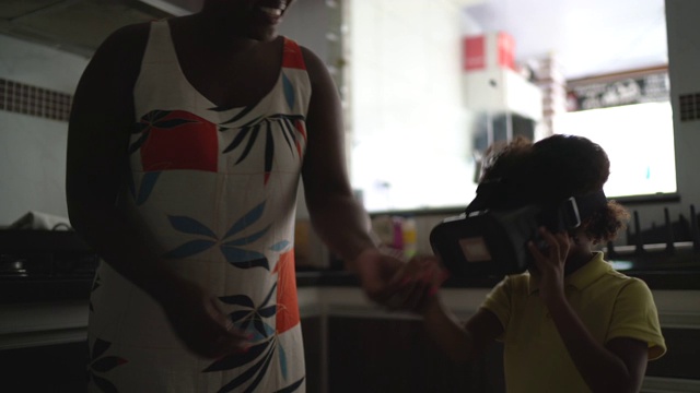 孩子与母亲在家里与虚拟现实眼镜互动视频素材