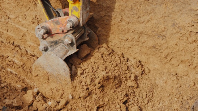 强大的挖掘机斗从坑中取出地面。在施工现场铺设通讯视频素材