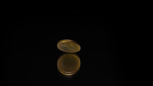 一枚欧元硬币在一面黑色的镜子上旋转视频素材