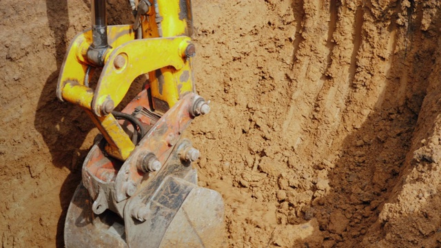 挖掘机斗由强大的液压驱动，从沟里清除土壤。管道铺设视频下载
