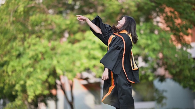 一位从大学毕业的亚洲女毕业生微笑着祝贺她大学毕业。视频下载