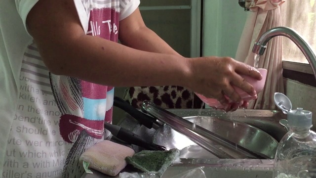 在厨房里用海绵洗盘子的女人视频素材