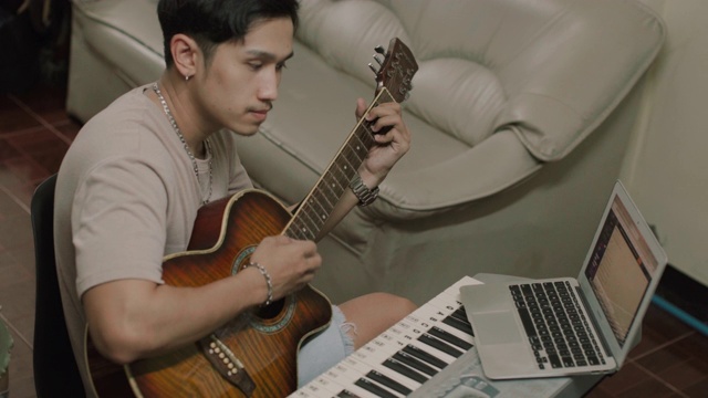 亚洲男子学习弹吉他在家库存视频视频素材