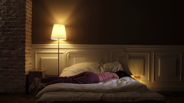 一个漂亮的女孩很晚才进来睡觉，躺在毯子上。视频下载