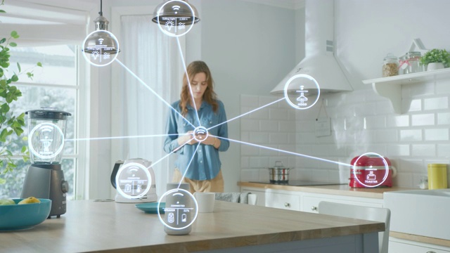 物联网概念:年轻女性在厨房使用智能手机。她用物联网控制厨房电器。图形显示连接的家庭电子设备的数字化可视化视频素材