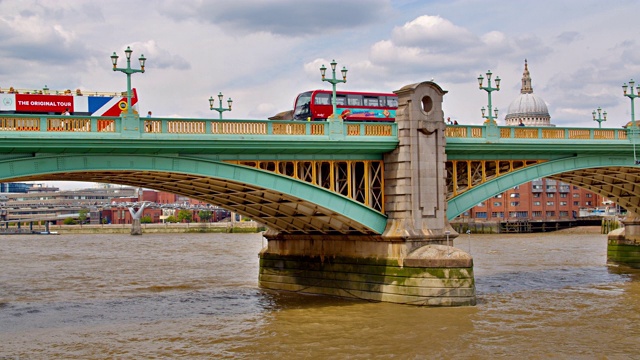 红色巴士通过伦敦大桥。云和天空。河。视频素材
