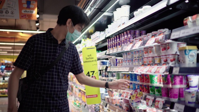 年轻男子戴着防护口罩在超市购物视频素材