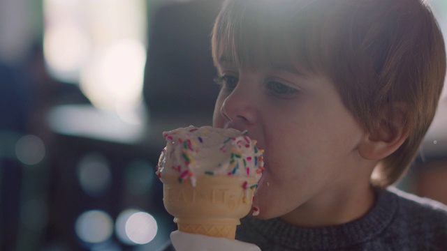 SLO莫。铜。一个蹒跚学步的小男孩一边吃着香草冰淇淋，一边笑着视频素材