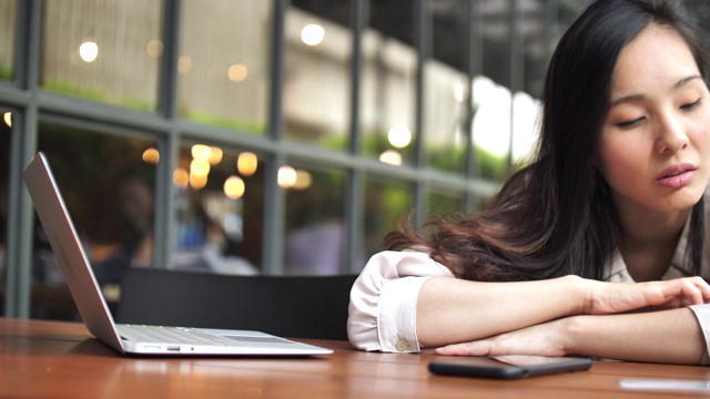 劳累过度的女商人睡在她的笔记本电脑上视频素材
