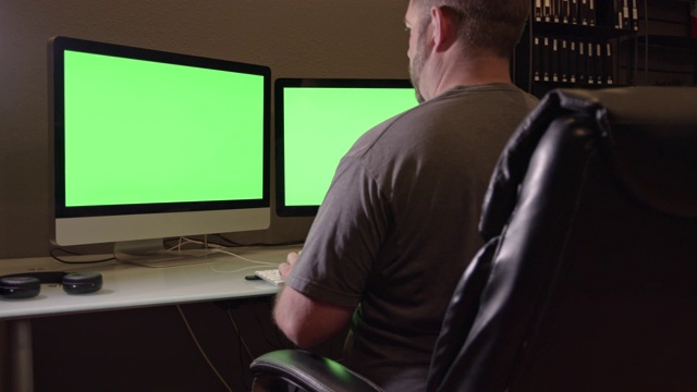 人使用绿色屏幕的双屏电脑视频下载