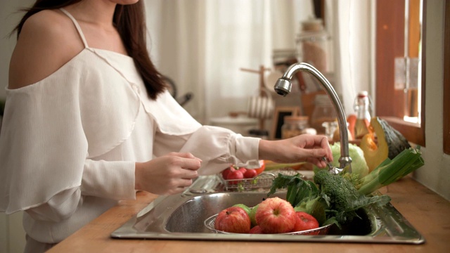 隔离:妇女在家用手洗蔬菜视频下载