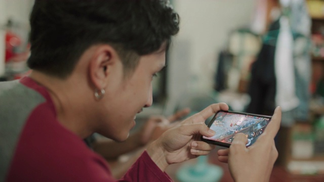 亚洲男人在客厅里和朋友玩电子游戏视频素材