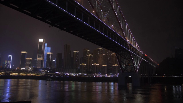 中国，亚洲，重庆，渝中区，船上游船拍摄城市天际线和灯光照亮的桥梁视频下载