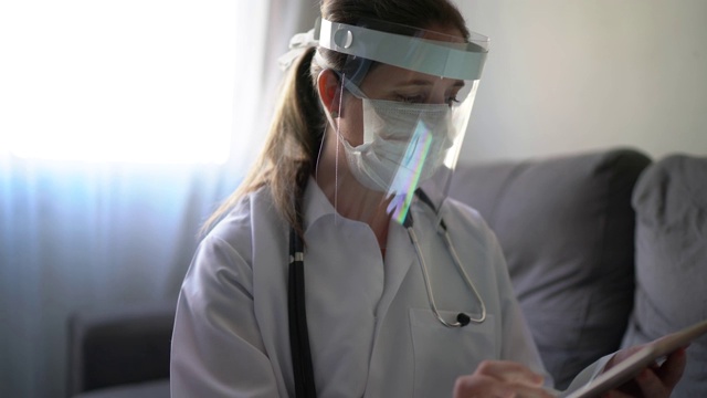 医生和病人在病人家里使用数字平板电脑进行医疗咨询视频素材
