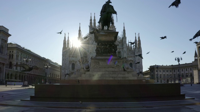 2020年大流行封锁期间，一群鸽子在维托里奥·埃马努埃莱二世雕像前的米兰大教堂前飞翔。空城的早晨。视频下载