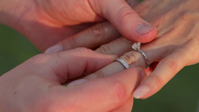在婚礼上，新郎把戒指戴在新娘的手上。视频素材