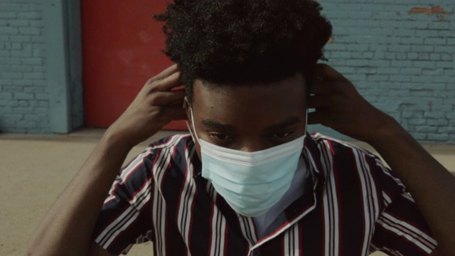 在大流行病毒爆发期间户外佩戴口罩的城市黑人男性4K视频系列视频素材
