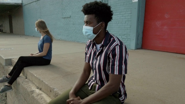 城市居民、黑人男性和白人女性在大流行病毒爆发期间戴口罩的户外活动4K系列视频视频素材