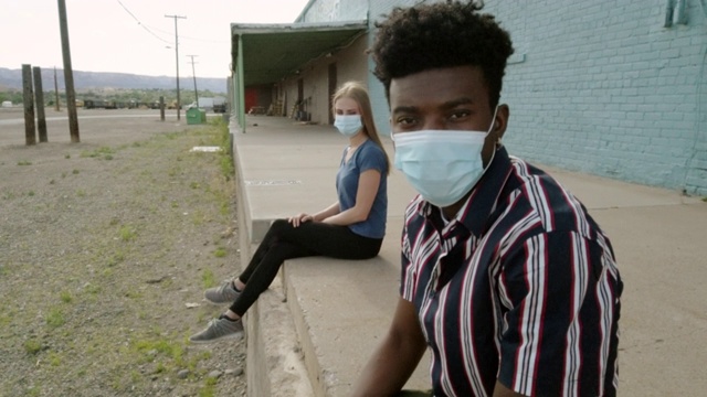 城市居民、黑人男性和白人女性在大流行病毒爆发期间戴口罩的户外活动4K系列视频视频素材