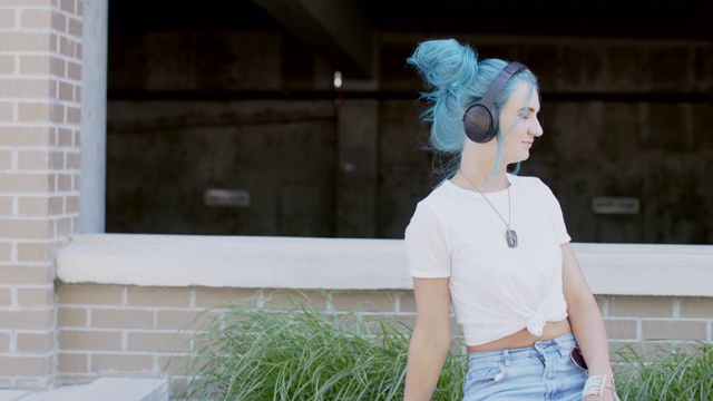 独特，活泼，时尚的年轻千禧女性在夏天户外听无线蓝牙耳机视频素材