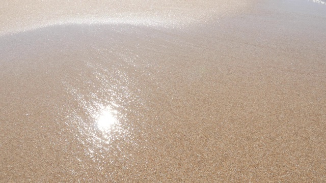 浅浅的波光粼粼的海水在海滩上缓慢地蔓延视频下载