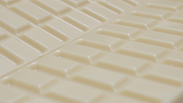 白色的牛奶巧克力块排缓慢倾斜4K视频下载