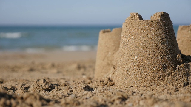 沙滩上的沙堡，以海浪为背景的慢动作视频素材