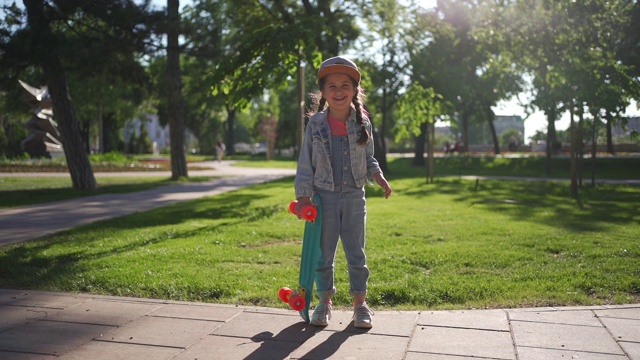 可爱自信的小滑板女孩和她的绿色滑板视频素材