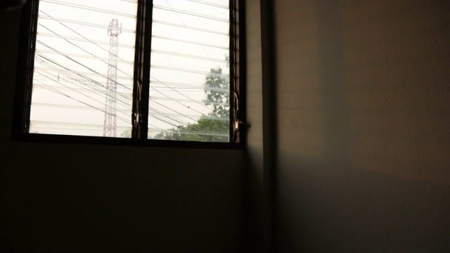 时间流逝:阳光透过建筑角落的百叶窗照射进来。视频素材