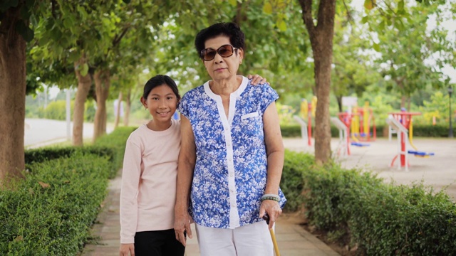 亚洲老年妇女在公园散步她的孙子，生活理念。视频下载