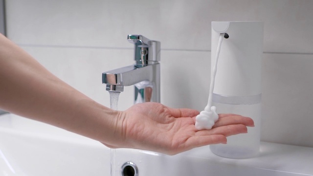 自动泡沫发生器将所需剂量的肥皂放在手上。浴室里的现代科技。女人的手视频下载