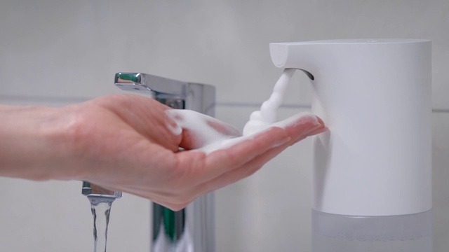自动泡沫发生器将所需剂量的肥皂放在手上。女性的手需要护理和卫生。视频下载