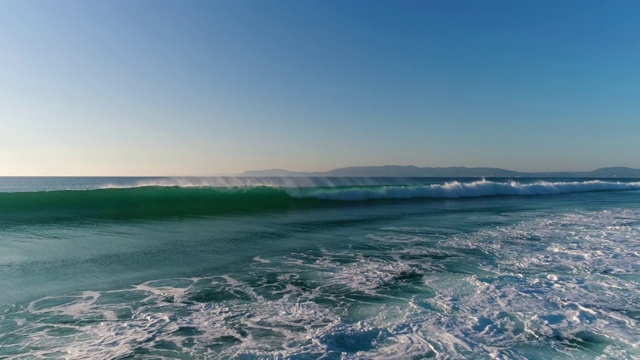 鸟瞰图的波浪打破在康波塔海滩与阿拉比达山脉的背景视频下载