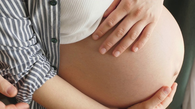 父母用手触摸孕妇的肚子视频素材