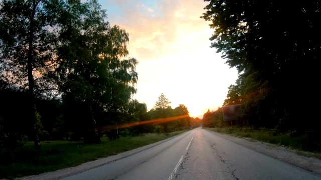 在夕阳西下的乡间小路上开车视频素材