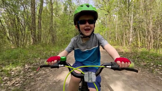 可爱的孩子在森林里骑车视频素材