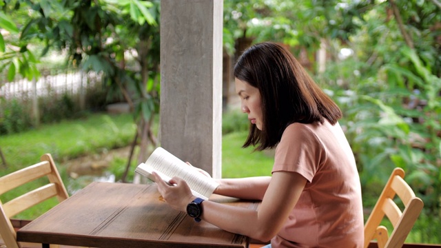 女人在家里看书，在户外视频素材