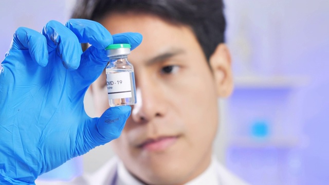 领导亚洲男性科学家手拿安瓿近距离接触病毒在科学实验室研究冠状病毒或Covid-19疫苗。科学实验室视频素材